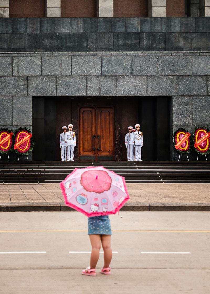 Vietnamese child pink umbrella Ho Chi Minh Mausoleum Hanoi Vietnam