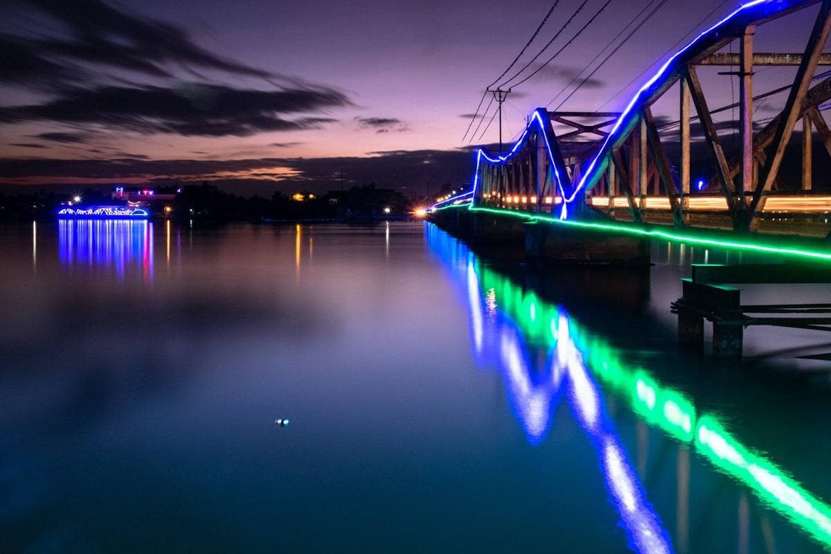 Old French bridge over Kampot River at dusk. Kampot, Cambodia.