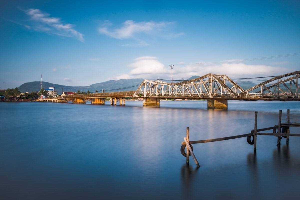 Old French bridge over Kampot River in the morning. Kampot, Cambodia.