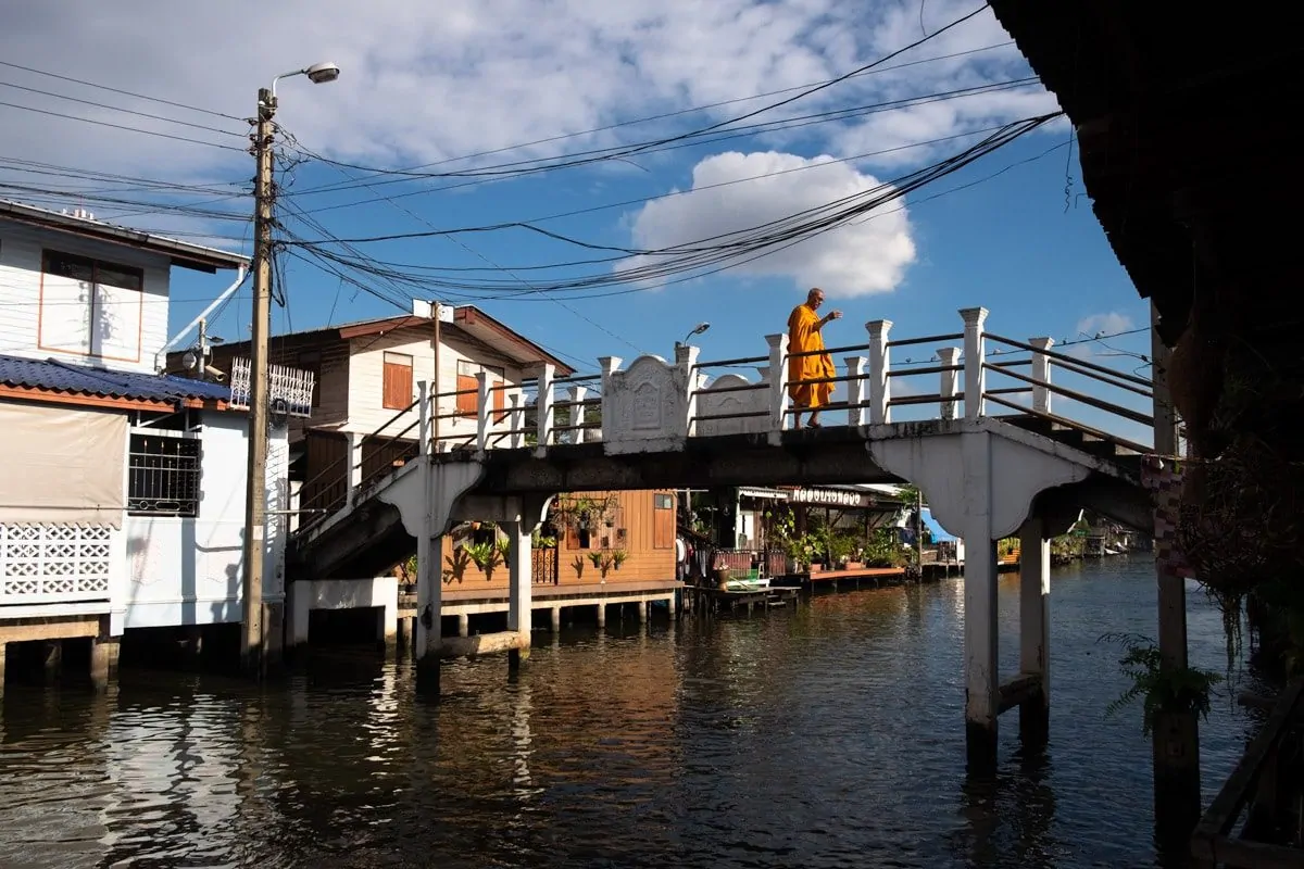 A Buddhist monk crosses Bang Luang Canal over a bridge.