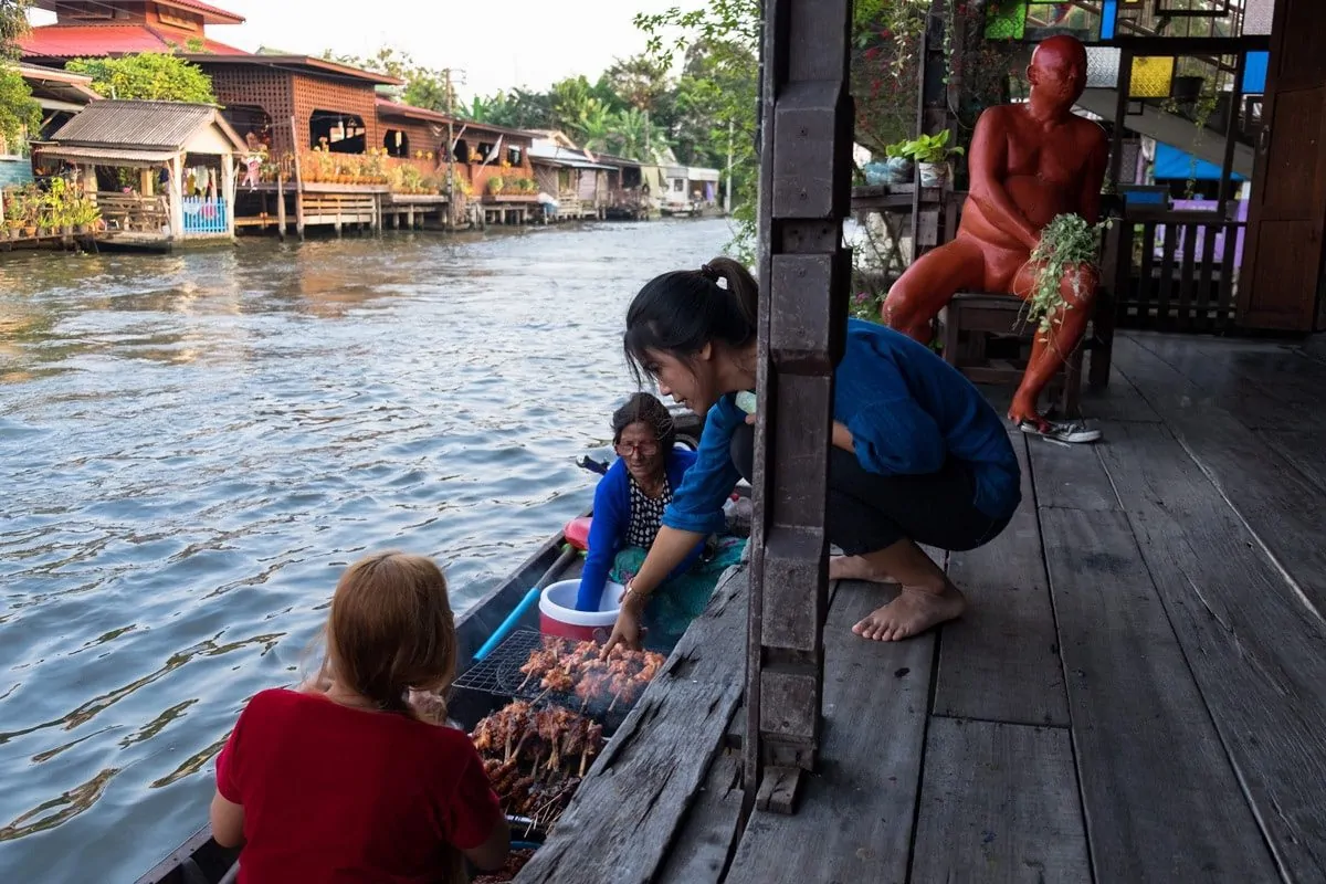 A customer points to barbecue chicken sold on a boat.