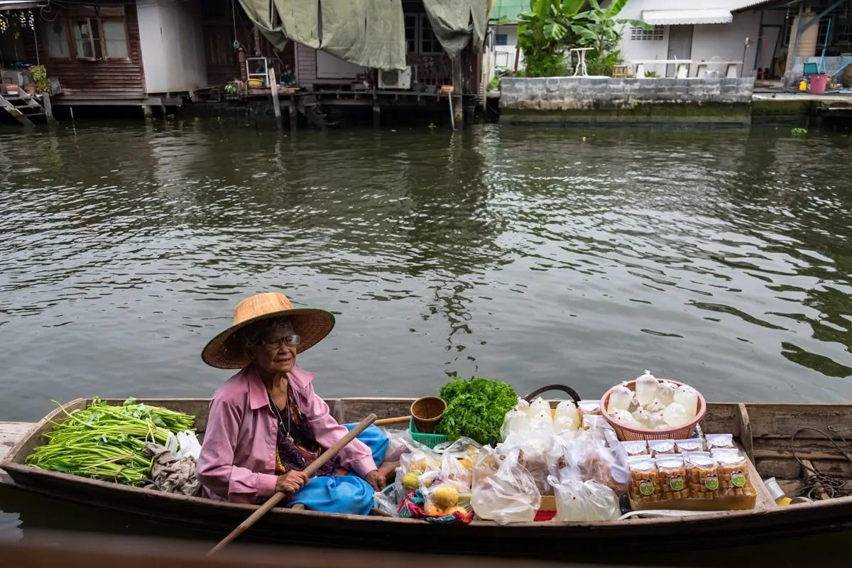 Thai snack vendor on a boat awaits customers at Bang Luang Canal.