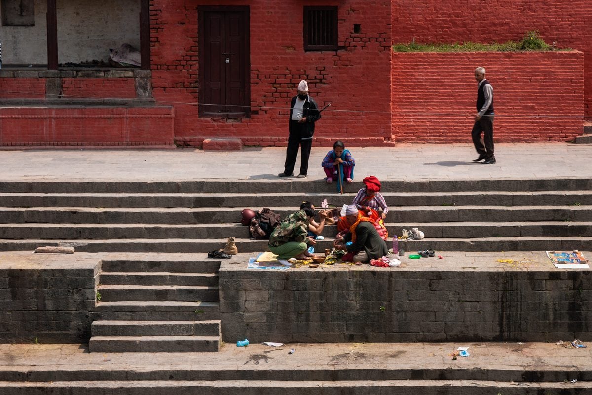 Nepalese family seat on the bank of the Bagmati River at Pashupatinath Temple in Kathmandu, Nepal.