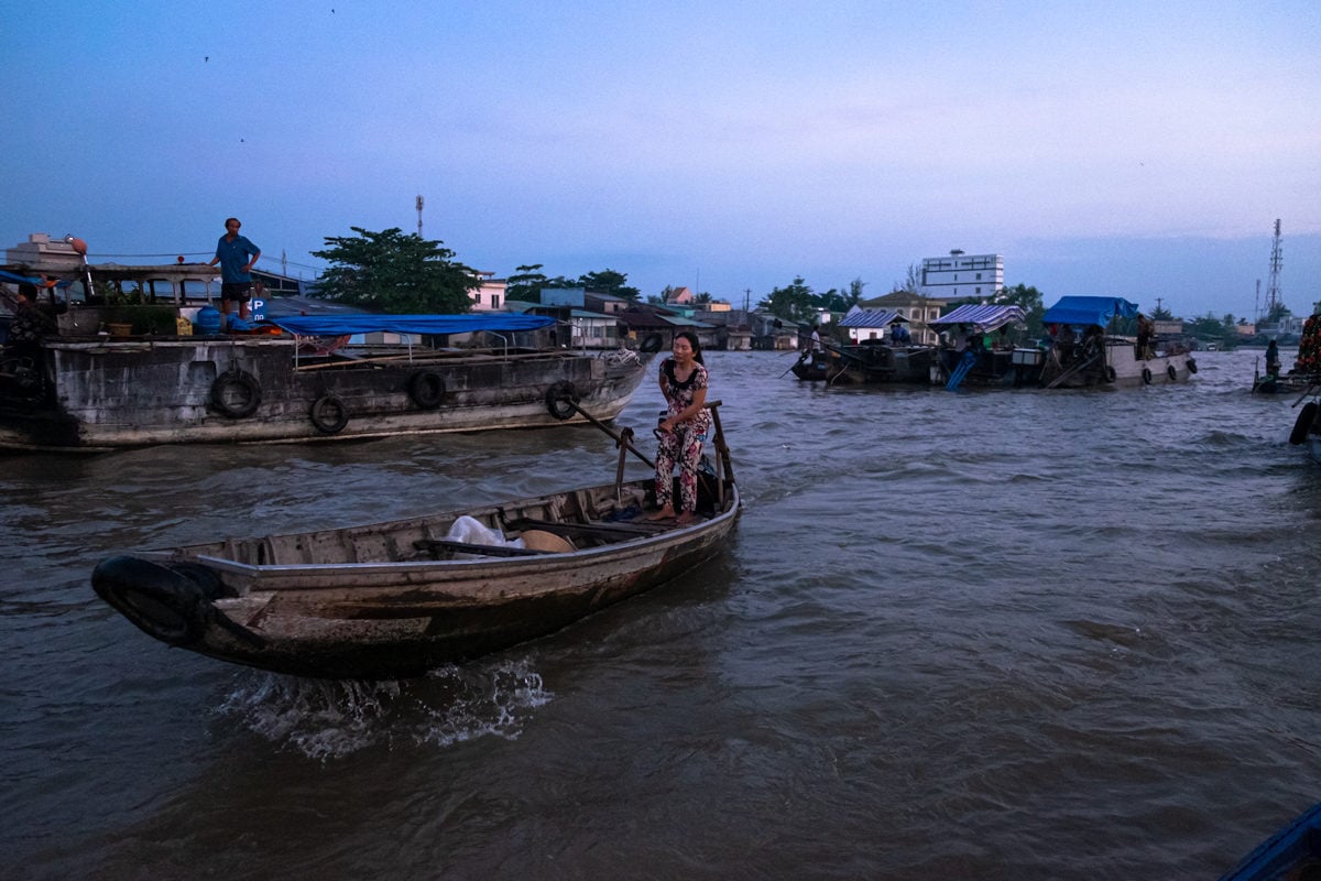 Sleepy Vietnamese woman on her little boat at Cai Rang floating market on the Mekong Delta. Can Tho, Vietnam.