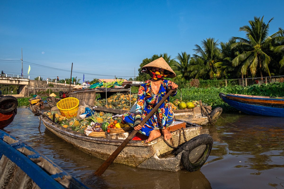 Vietnamese fruit seller sits on her boat on Phong Dien floating market. Mekong Delta, Can Tho, Vietnam.