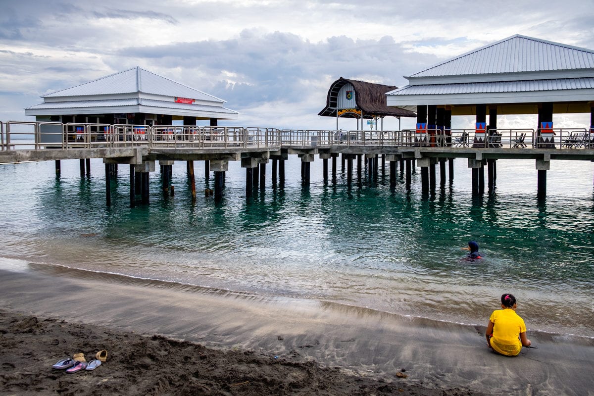 Woman enjoys a swim at Senggigi Pier. Lombok Island, Indonesia.
