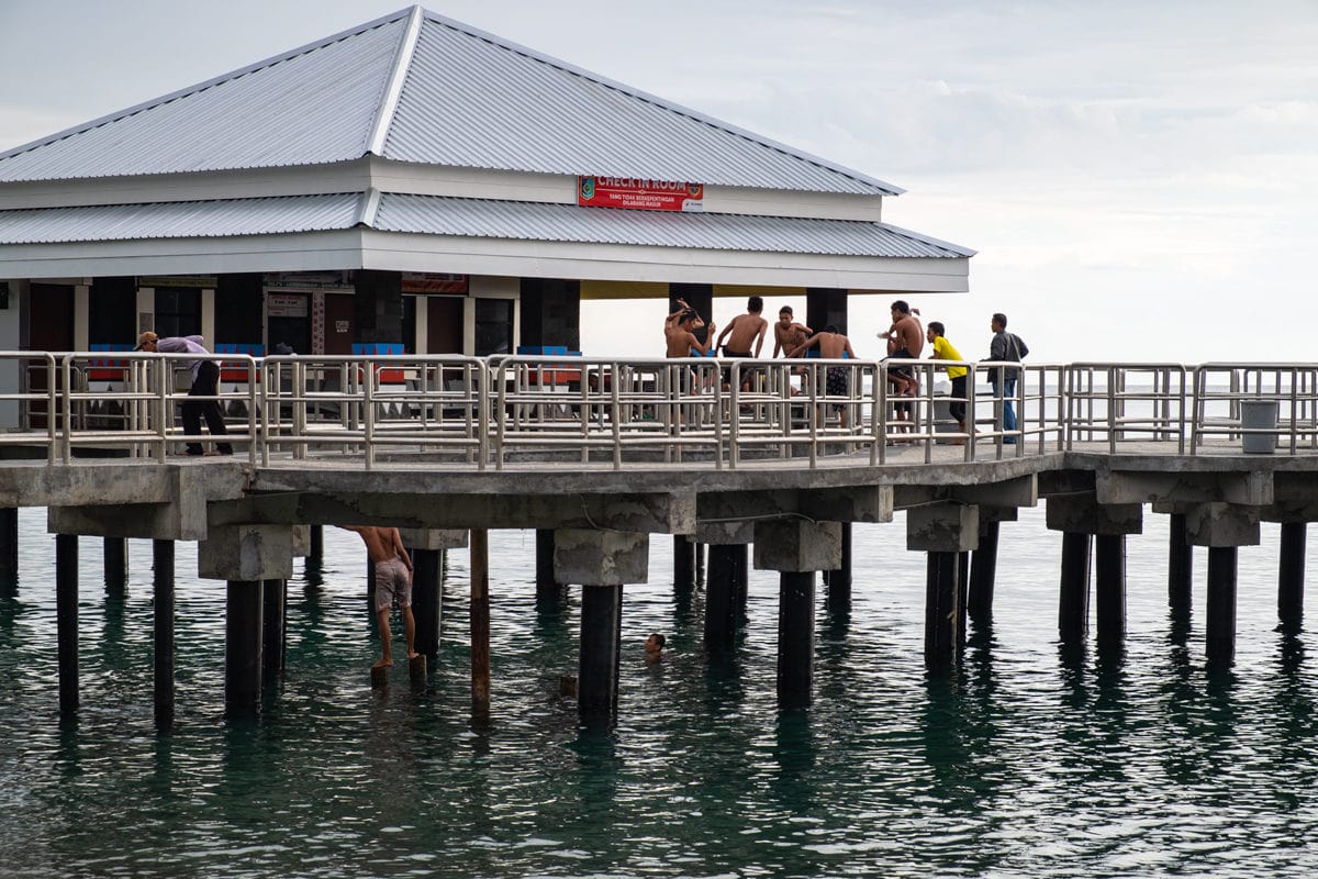 Young Indonesians enjoy a dive from Senggigi Pier. Lombok Island, Indonesia.
