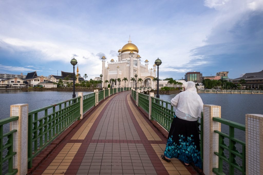 Follower of Islam on the bridge of the Sultan Omar Ali Saifuddien Mosque. Bandar Seri Begawan, Brunei.