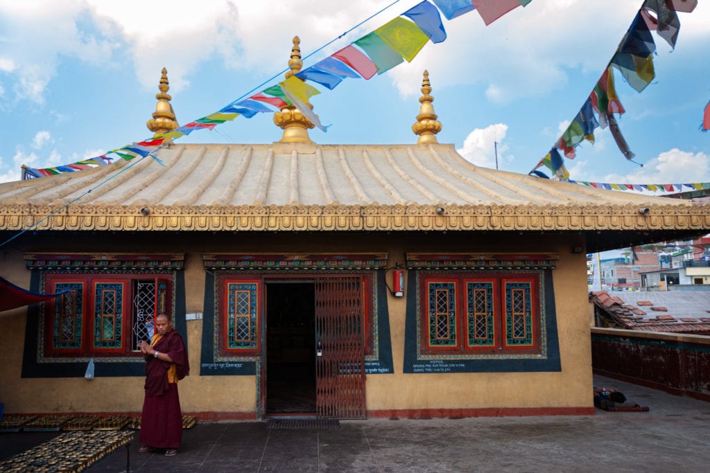 A Buddhist monk is in front of a Buddhist Monastery near Boudhanath Stupa. Kathmandu, Nepal.