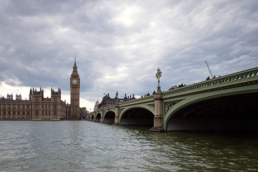 Westminster Bridge with the Palace of Westminster and the Big Ben. London, Uk. Many people walk on the bridge.