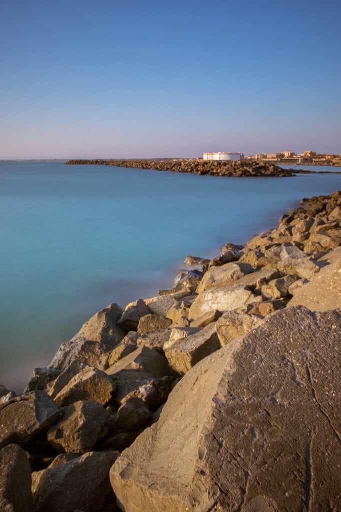 Long exposure image of Rock armour beach at Molo (pier) di Fiumicino. Rome, Italy. Sea water looks silky and smooth.